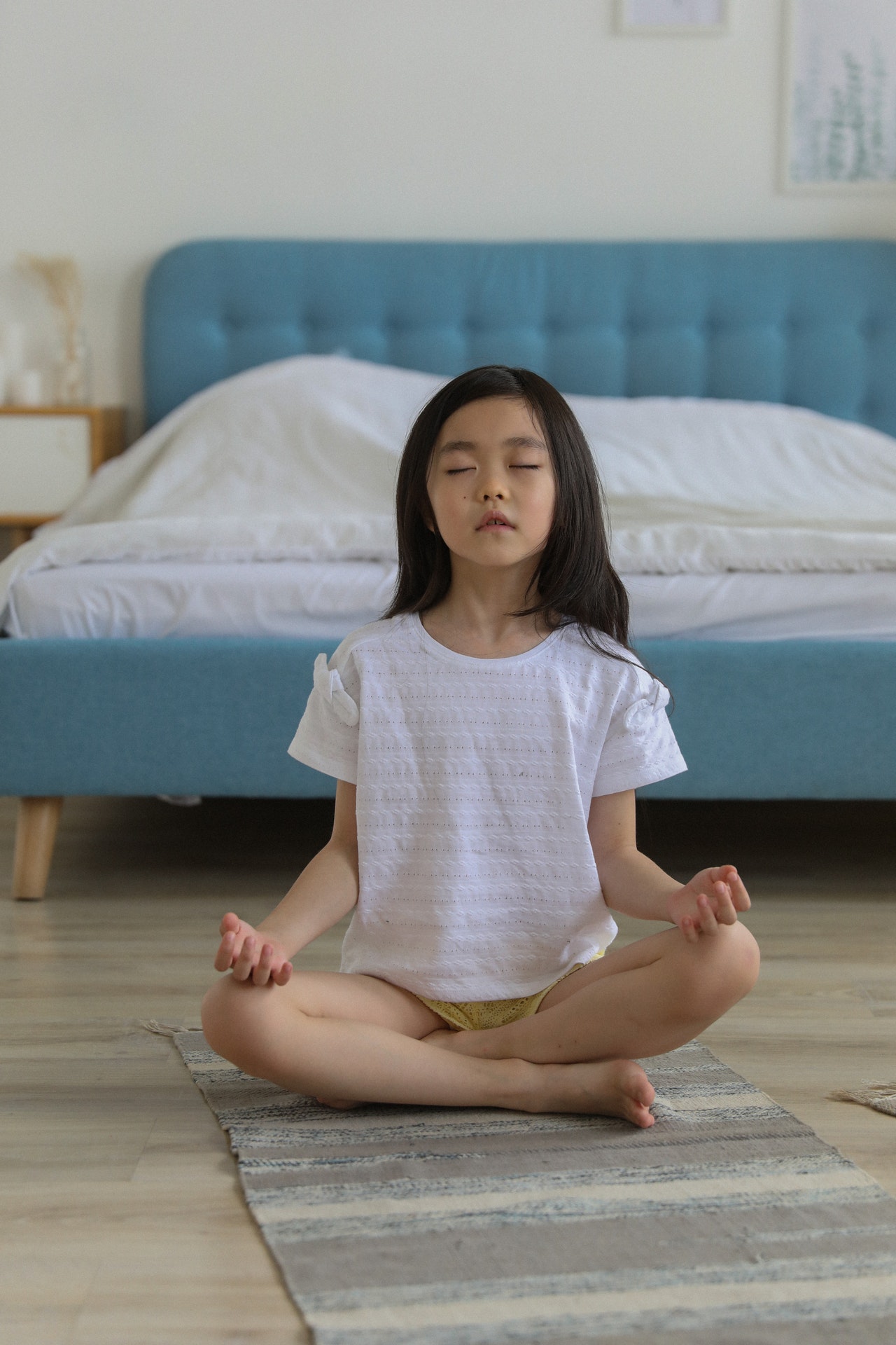 menina de ascendência asiática meditando em um quarto