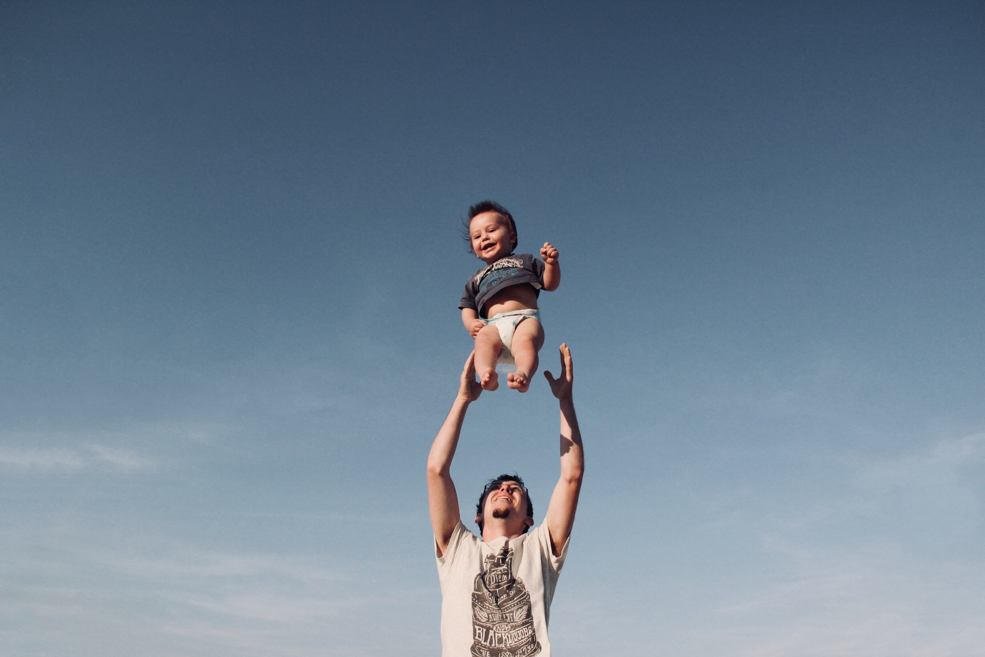 homem jogando bebê ao alto