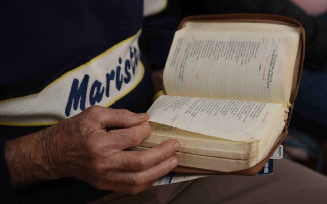mãos de um irmão marista segurando uma bíblia