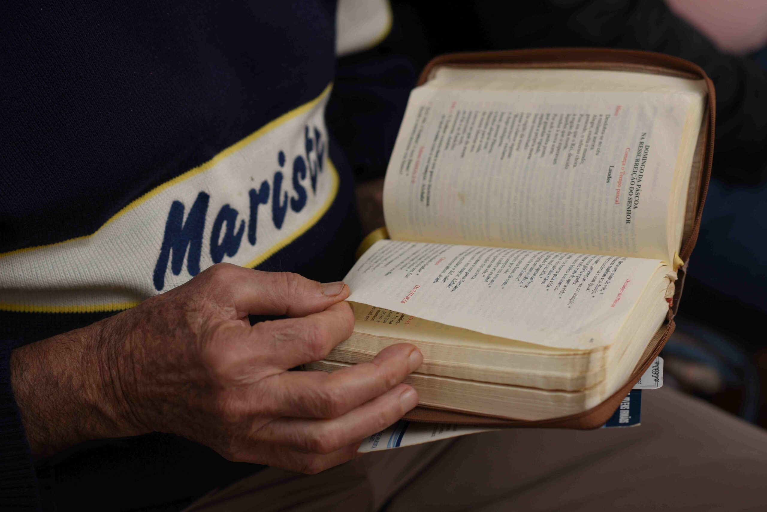 mãos de um irmão marista segurando uma bíblia